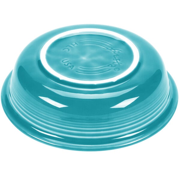 A turquoise bowl with a white rim.