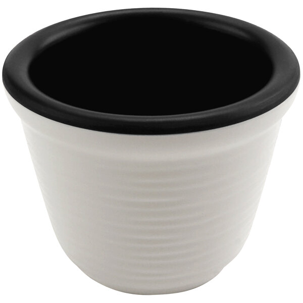 A black melamine ramekin with a white interior and black rim.