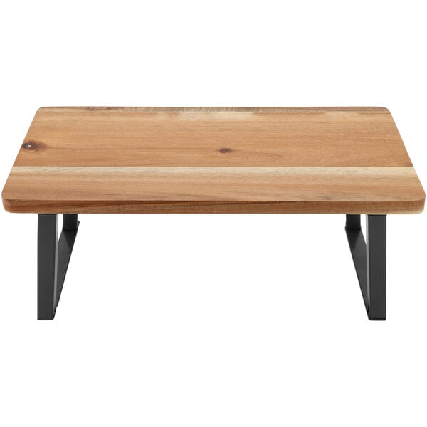 A GET Heights wood riser with foldable legs on a wooden table.