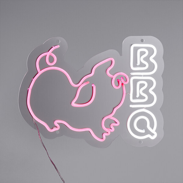 A Canvas Freaks neon sign that says "BBQ" in pink and white letters.