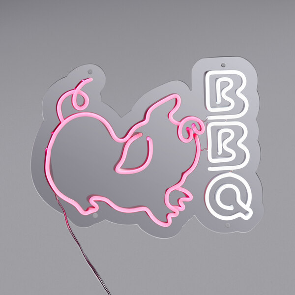 A Canvas Freaks neon sign with the word "BBQ" in pink and white.