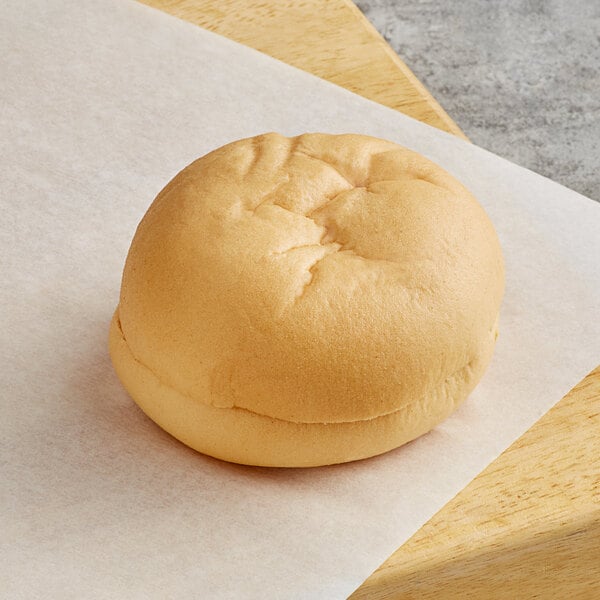 A Schar gluten-free hamburger bun on a piece of paper.