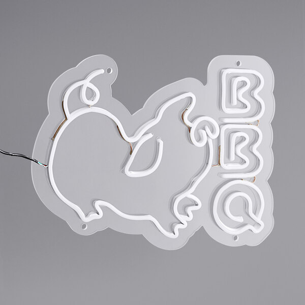 A Canvas Freaks white neon sign with the word "BBQ" and a pig.