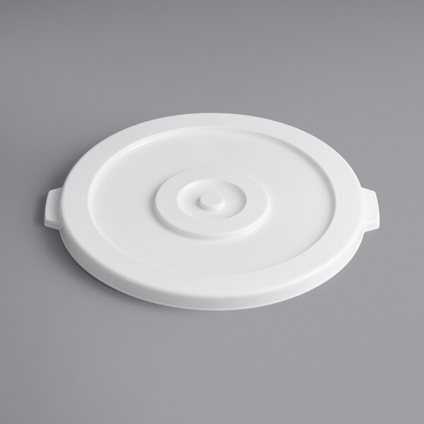 A white plastic lid with a circle on a gray surface.