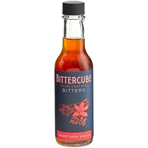 A bottle of Bittercube Cherry Bark Vanilla Bitters on a table in a cocktail bar.
