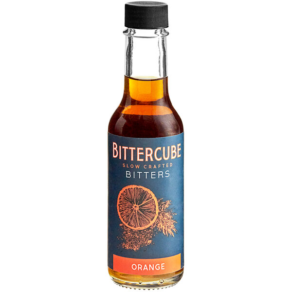 A bottle of Bittercube Orange Bitters on a table in a cocktail bar.
