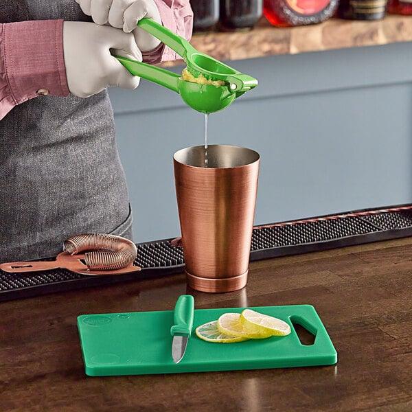 Juicing a lime with a green hand juicer