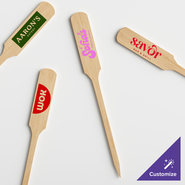 A group of customizable wooden paddle picks with writing on them.