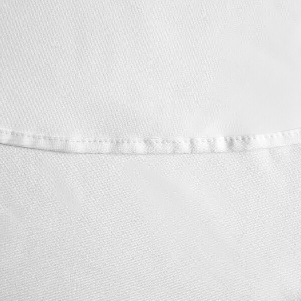 A close up of a white polyester table cover with a hemmed edge.