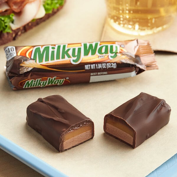 A close up of a MILKY WAY chocolate bar with a caramel filling.