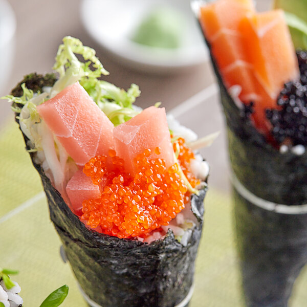 A sushi roll with orange Cavi-Art on top.