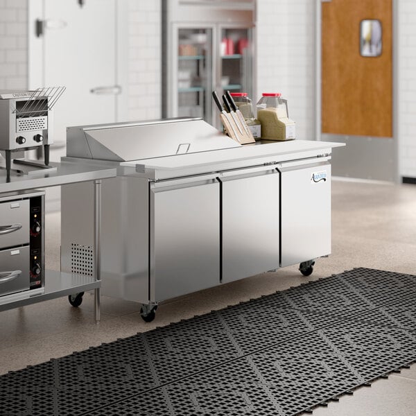 An Avantco stainless steel sandwich prep table on a large counter.