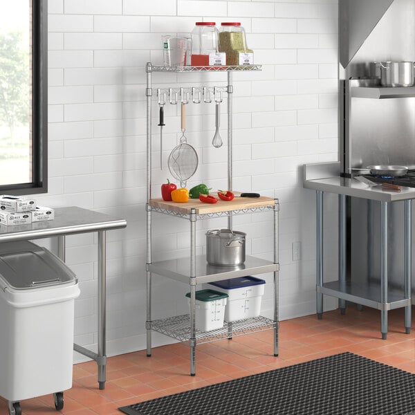 A Regency chrome wire baker's rack with stainless steel and wood shelves in a kitchen.