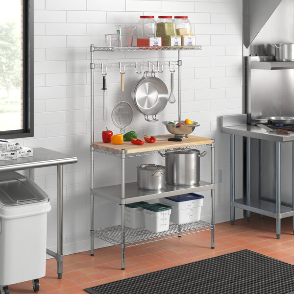 A Regency wire baker's rack with a solid stainless steel shelf and a cutting board on a counter in a kitchen.