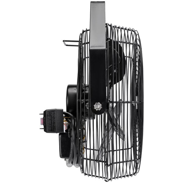 A close up of a black Tornado metal wall fan with a wire attached.