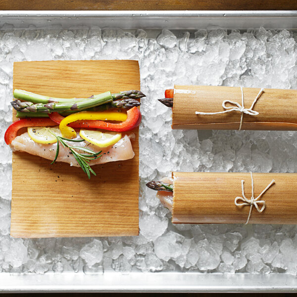 Wildwood Grilling wraps used to cook chicken and vegetables on a wooden surface.