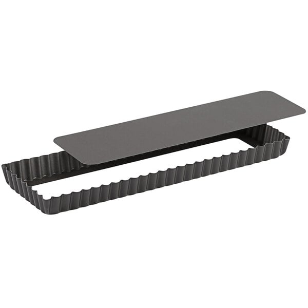 A black rectangular Gobel tart pan with a fluted edge and a removable bottom.