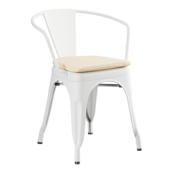 A Lancaster Table & Seating white metal outdoor arm chair with a tan cushion.