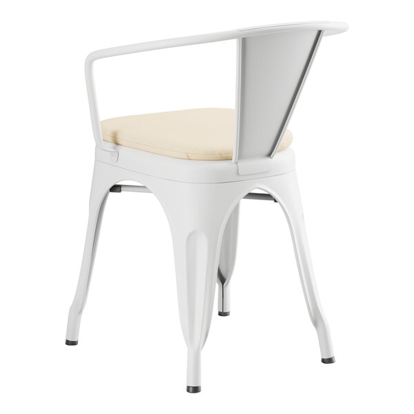 A Lancaster Table & Seating white outdoor arm chair with a cushion on top.