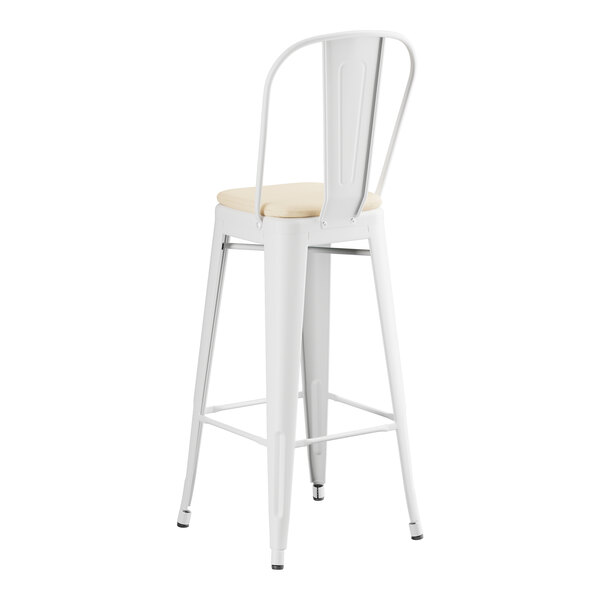 A white Lancaster Table & Seating outdoor cafe barstool with a tan cushion.