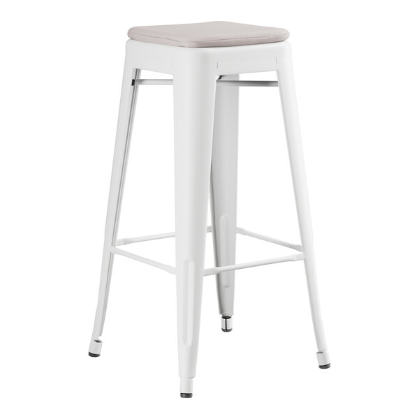 A Lancaster Table & Seating white outdoor backless barstool with a gray cushion.