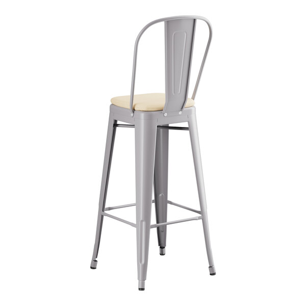 A Lancaster Table & Seating gray metal outdoor cafe barstool with a tan cushion.