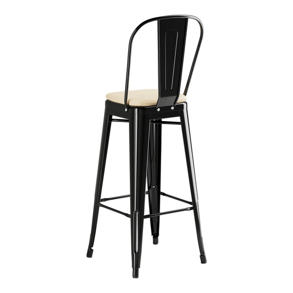 A black Lancaster Table & Seating outdoor cafe bar stool with a tan cushion.