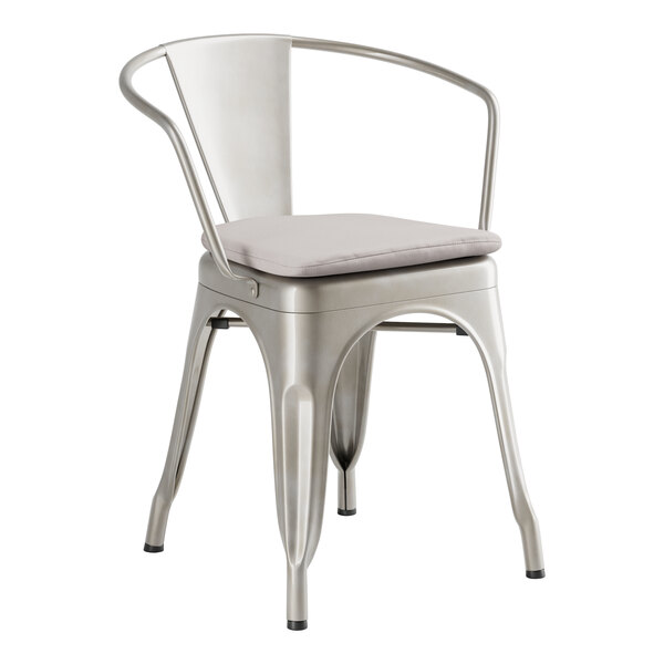 A Lancaster Table & Seating silver metal arm chair with a gray cushion.