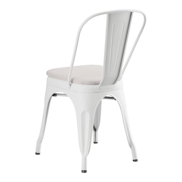 A Lancaster Table & Seating white metal outdoor cafe chair with a gray cushion.