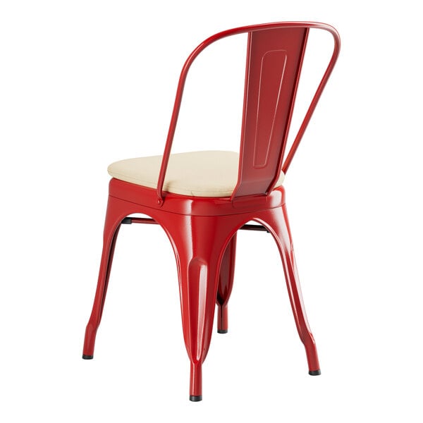 A red Lancaster Table & Seating outdoor cafe chair with a tan cushion.