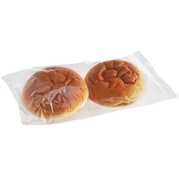 Two King's Hawaiian Original Hawaiian Sweet sandwich rolls in plastic bags.