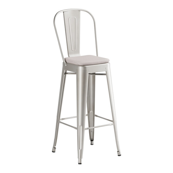 A Lancaster Table & Seating metal bar stool with a gray cushion.