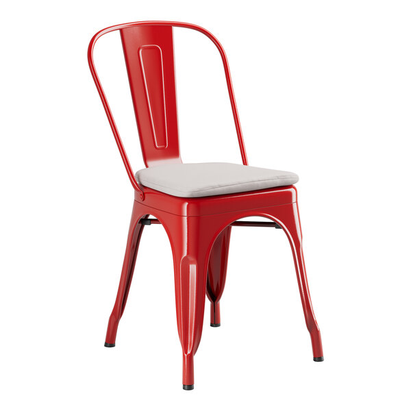 A red metal Lancaster Table & Seating outdoor cafe chair with a gray cushion.