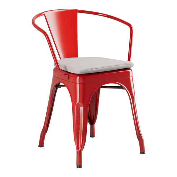 A Lancaster Table & Seating red metal outdoor arm chair with a gray cushion.