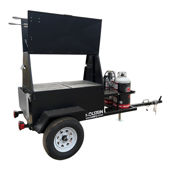 A towable propane grill with a stainless steel rotisserie attachment.
