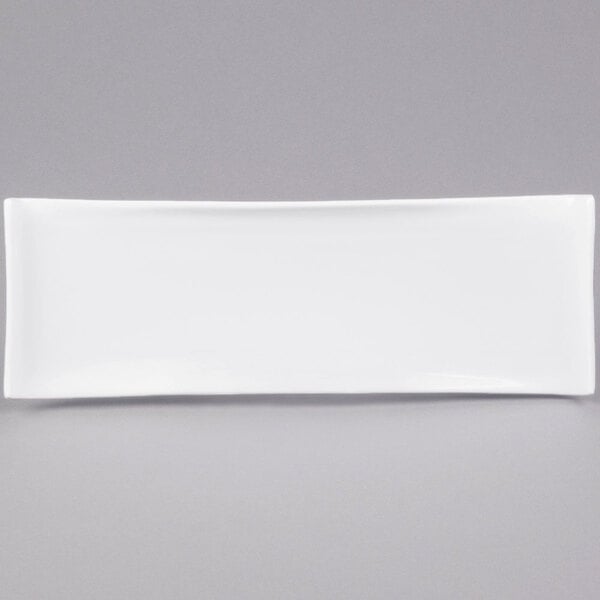 An American Metalcraft white rectangular porcelain serving platter with curved edges on a gray background.