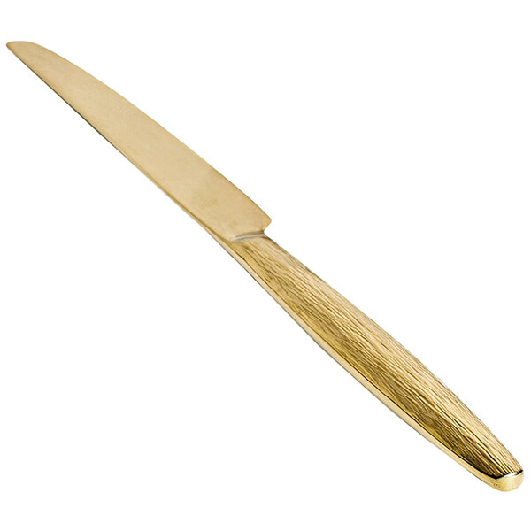 A Front of the House Owen dinner knife with a matte brass handle.
