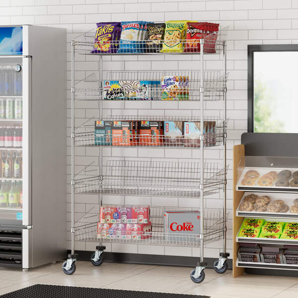 A Regency chrome metal retail display stand with shelves of snacks and drinks.