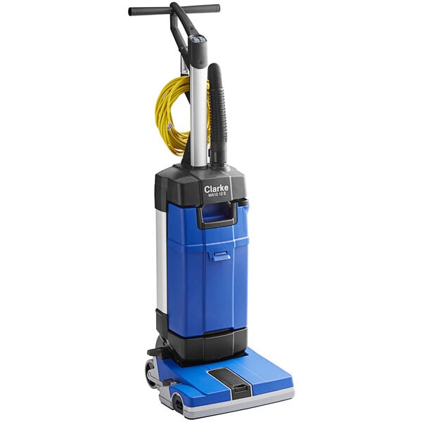 A blue and black Clarke MA10 12E walk behind cylindrical floor scrubber.