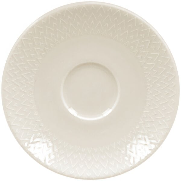 A RAK Porcelain ivory porcelain saucer with an embossed pattern and circular edge.