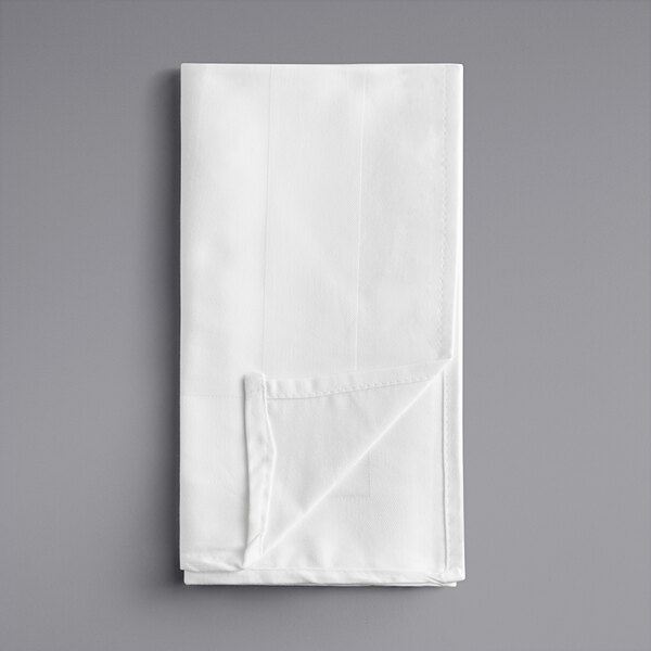 A folded white Oxford cloth napkin on a gray surface.