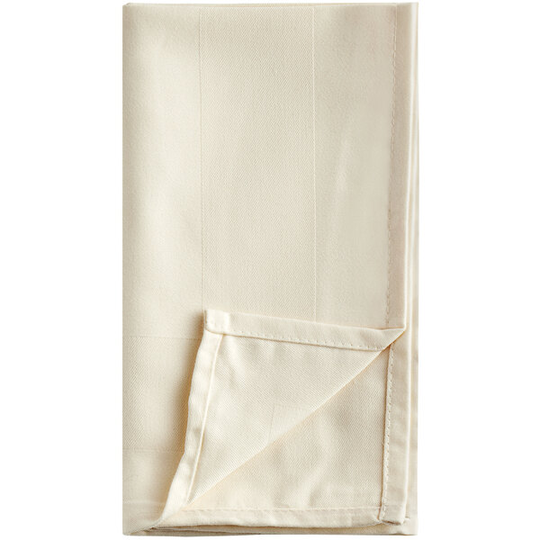 A close-up of a white folded Oxford Ivory cloth napkin.