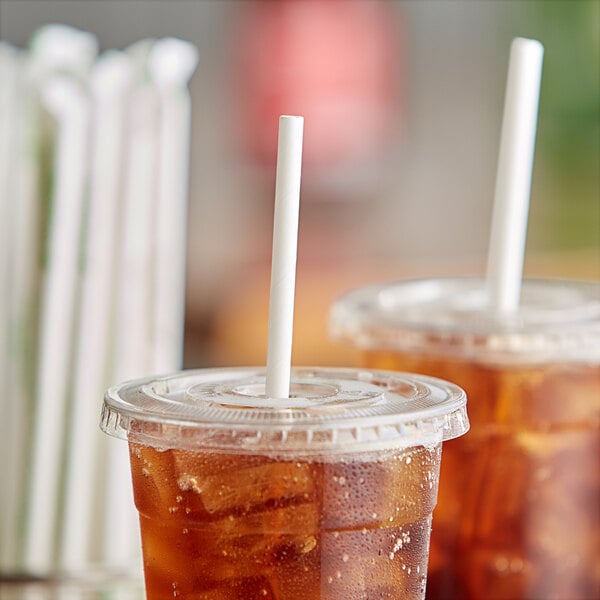 A close-up of two plastic cups with True Green white wrapped bamboo straws in them.