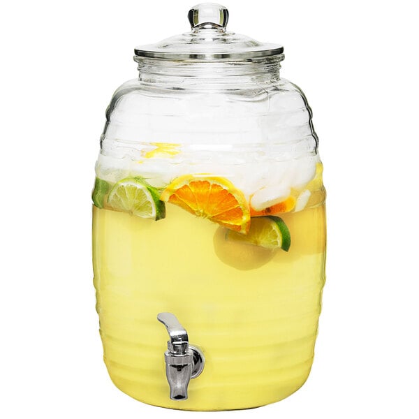 A Stylesetter glass beverage dispenser filled with lemonade and fruit slices.