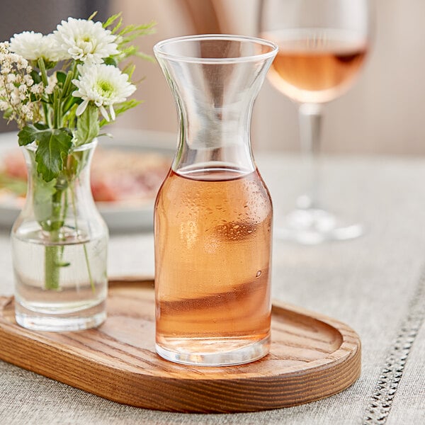 A Libbey glass cocktail decanter filled with flowers on a table.