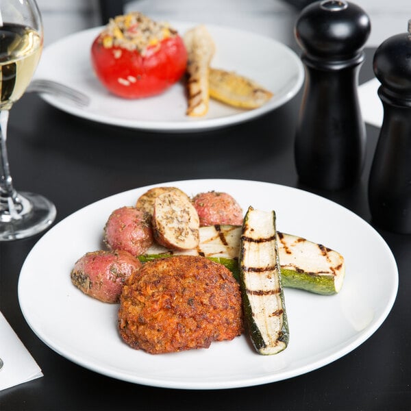 A Tuxton bright white china plate with food on a table