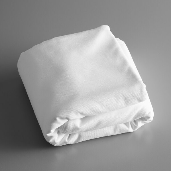 A folded white Intedge tablecloth on a gray surface.