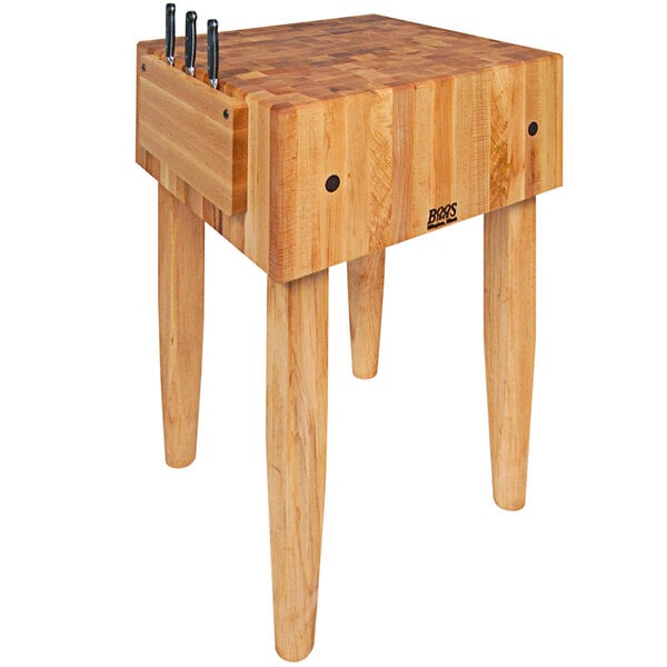 A John Boos maple butcher block with knives on top.