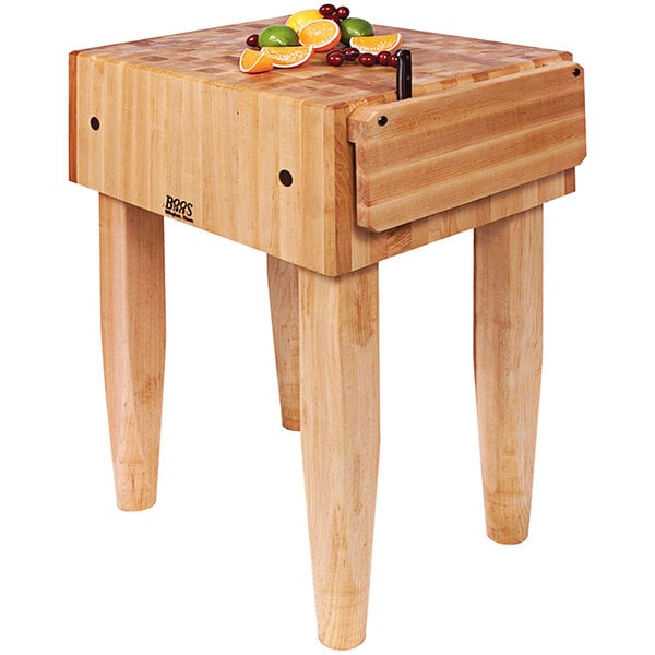 A John Boos maple butcher block with a knife on it.