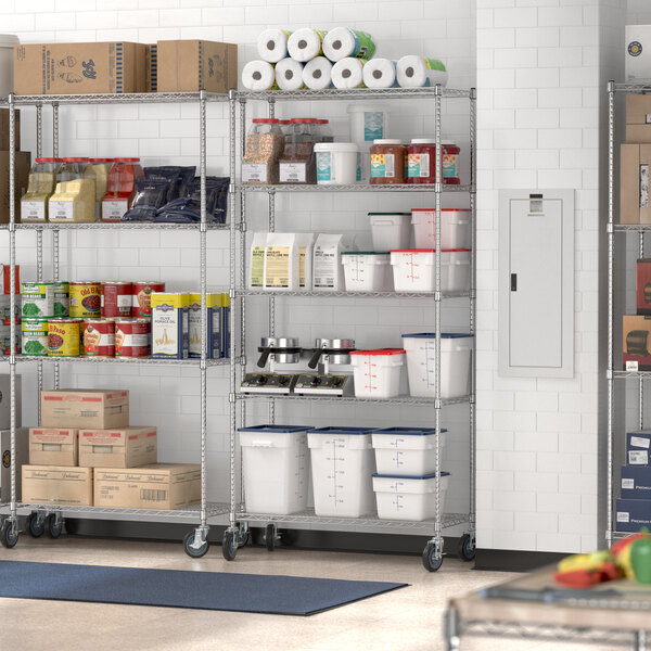 Regency stainless steel wire shelving unit with food items on shelves in a large kitchen.